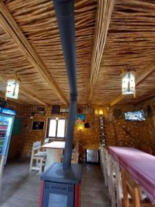 a wood stove in a restaurant with a ceiling at Vilat Suka Mkushit in Gropat e Selcës