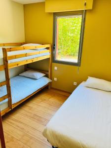 2 łóżka piętrowe w pokoju z oknem w obiekcie Le Domaine d'Arignac w mieście Arignac