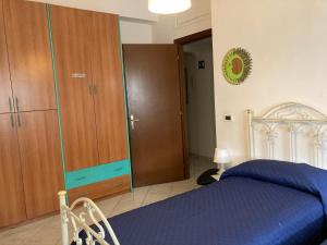 ein Schlafzimmer mit einem blauen Bett und einem Holzschrank in der Unterkunft Aroma Di Mare in Lido di Ostia