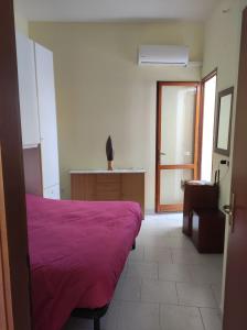 1 dormitorio con 1 cama con manta morada en Appartamento centro storico, en SantʼAntìoco
