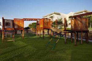 een groep houten banken op het gras bij Double room with garden in Sharm El Sheikh