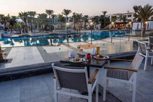 een tafel met eten naast een zwembad bij Double room with garden in Sharm El Sheikh