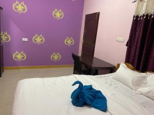 ein Schlafzimmer mit einem Bett und einem blauen Handtuch darauf in der Unterkunft Hotel PNR'S Paradise in Udagamandalam