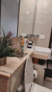 ムンバイにあるTrendy1BR+smart kitchen +Living room+1.5 toiletsのバスルーム(洗面台、トイレ、鏡付)