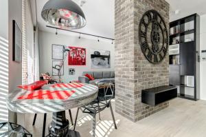 a living room with a table and a brick wall at Dom & House - Apartamenty Nadmorski Dwór in Gdańsk