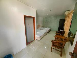 a room with a bedroom with a bed and a chair at Marang Village Resort in Marang