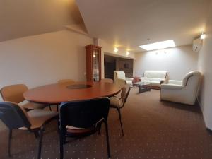 a room with a table and chairs and a couch at Apartamentai "Tenisas" in Palanga