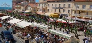Une foule de gens assis à des tables dans un marché dans l'établissement Bret, à Valras-Plage 5 autres photos
