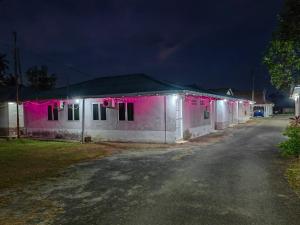 een wit gebouw met roze lichten er 's nachts op bij Marang Village Resort in Marang