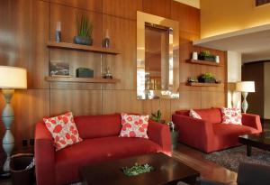 a living room with two red couches and a table at Hotel Angeleno in Los Angeles