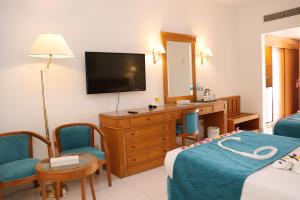 a hotel room with a bed and a television at MG Alexander The Great Hotel in Marsa Alam City
