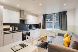 cocina y sala de estar con sofá y mesa en 4 Person Modern Apartment Nr City Centre, en Cardiff