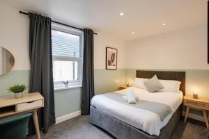 Un dormitorio con una cama grande y una ventana en 4 Person Modern Apartment Nr City Centre, en Cardiff