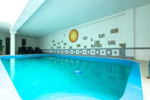 a swimming pool with blue water in a building at Hotel pod Zámkom in Bojnice