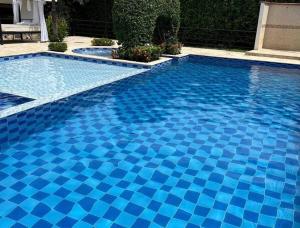 una piscina con azulejos azules. en Finca Sopetran, en Sopetrán