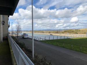 a bus driving down a road next to a body of water at Luxury 3 Specious Bedrooms Apartment in Edinburgh in Edinburgh