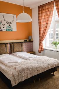 a bedroom with a bed with orange walls and a window at Maria Szczyrk in Szczyrk