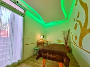 una camera da letto con un letto con luci verdi sul soffitto di Eco Hotel Montemerlo a Fetovaia
