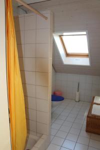 een badkamer met een dakraam en een witte tegelvloer bij Wirtshaus Rütihof in Gränichen