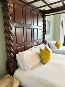 1 dormitorio con 2 camas y almohadas blancas y amarillas en La Di Da Hotel beach town, en Bournemouth