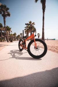 una bicicleta naranja estacionada en una acera cerca de la playa en Les Prairies de la Mer, en Grimaud