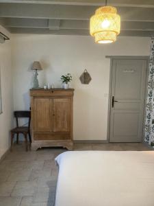 um quarto com uma cama, uma mesa e um candeeiro em Villas Les Loges em Les Loges