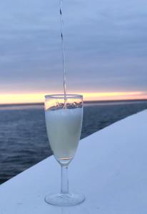 ein Glas Wein auf einem Tisch in der Nähe des Wassers in der Unterkunft Ferienwohnung Südpol, Pellworm in Pellworm