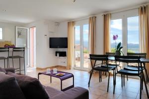 a living room with a couch and a table and chairs at Mini villa Marina Serena in Porto-Vecchio