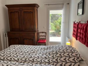 een slaapkamer met een bed, een dressoir en een raam bij Bel Appartement indépendant lumineux - St-Maximin in Saint-Maximin-la-Sainte-Baume