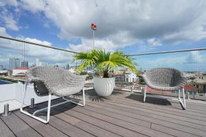 a balcony with two chairs and a plant on a roof at Luxury 1BR in Casco Viejo in Panama City