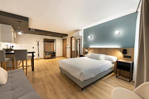 a bedroom with a bed and a desk and a table at Apartamentos Colón 27 in Palencia