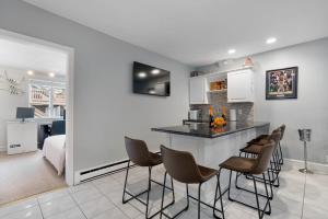 a kitchen and living room with a counter and chairs at Heart of Southie - Hot Tub + Walk to Top Bars in Boston
