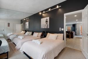three beds in a room with black walls at Heart of Southie - Hot Tub + Walk to Top Bars in Boston