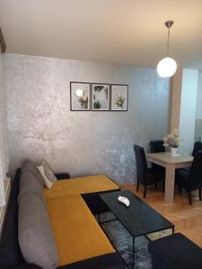 ein Wohnzimmer mit einem Sofa und einem Tisch in der Unterkunft Apartman Central in Bijeljina