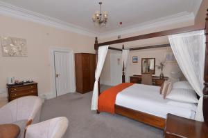 a bedroom with a large bed and a chair at Steeton Hall Hotel & Restaurant in Steeton