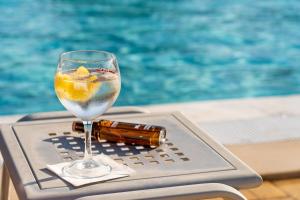 a glass of wine sitting on a tray next to a swimming pool at VILA PARK Nature & Business Hotel in Santo André