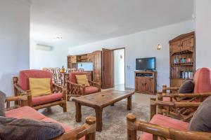 sala de estar con sillas, mesa y TV en Villa Noras, en Albufeira