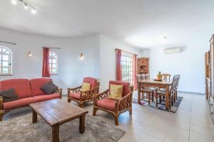 sala de estar con sofá, sillas y mesa en Villa Noras, en Albufeira