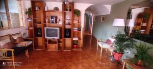 sala de estar con TV y algunas sillas en Panay Guest House, en Cusco