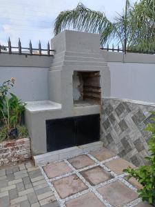 an outdoor pizza oven sitting on a patio at AMANI PALMS GUEST HOUSE in Klerksdorp