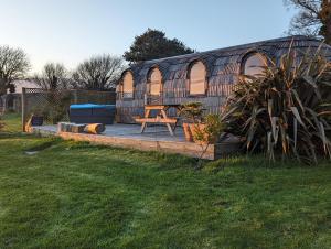 a yurt with a wooden deck with a picnic table at The Pasty - Lydcott Glamping in East Looe