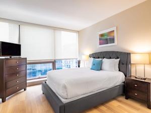 a bedroom with a large bed and a television at Family Friendly Apartment Downtown in Stamford