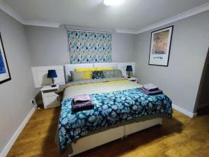 a bedroom with a bed with a blue and white comforter at The Nook located in a beautiful garden setting with parking in Stratford-upon-Avon