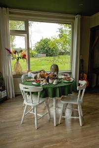 una mesa con un mantel verde y sillas en B&B Borgersteeg, en Neede