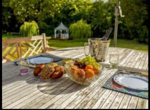 a wooden table with a bowl of fruit on it at The Nook located in a beautiful garden setting with parking in Stratford-upon-Avon