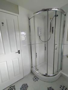 a shower with a glass door in a bathroom at The Nook located in a beautiful garden setting with parking in Stratford-upon-Avon