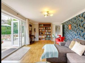 uma sala de estar com um sofá e uma mesa em The Nook located in a beautiful garden setting with parking em Stratford-upon-Avon