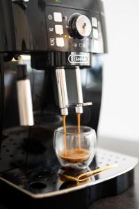 Una cafetera está vertiendo café en una taza en 130m2 Loft - Dachterrasse, Netflix, Badewanne, Kaffee, en Rosenheim