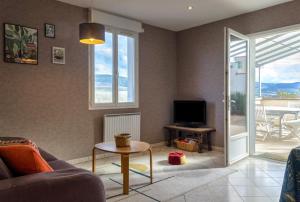 een woonkamer met een bank, een tv en een tafel bij Terre du Vivant in Cluny