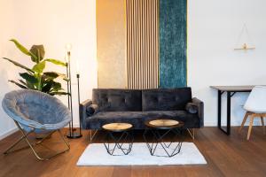 uma sala de estar com um sofá, uma cadeira e uma mesa em 130m2 Loft - Dachterrasse, Netflix, Badewanne, Kaffee em Rosenheim